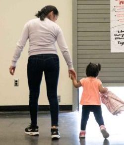 Woman and little girl walking hand-in-hand.