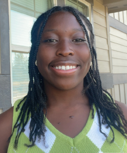 girl in green sweater smiles at camera