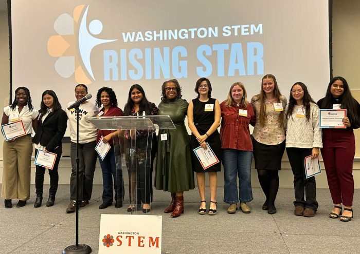 Students and Lynne K. Varner line up on a stage