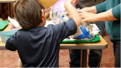 boy making piñata at table