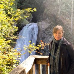 Joanne stands on a platform in front of a waterfall at Olallie State Park.