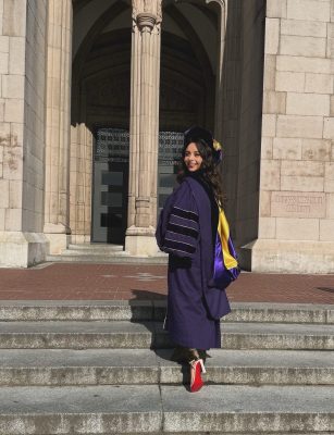 Henedina Tavares in purple graduation garb on the steps of Suzzallo library on University of Washington campus